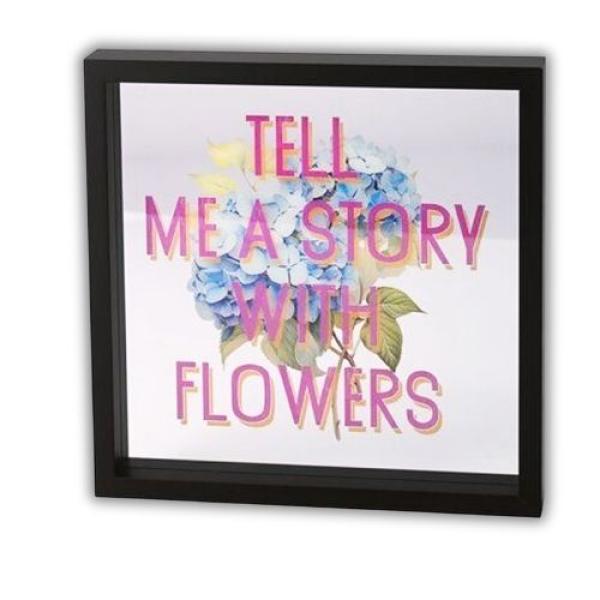 Love Frames Glasbild "Tell Me A Story With Flowers" mit blauer Hortensie und pinkem Schriftzug, schwarzer MDF-Rahmen – florale Wanddekoration