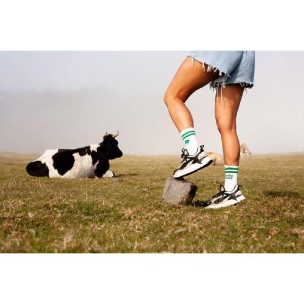 Sportler trägt Pegada Lucky Socks auf einer Kuh-Weide für besseren Halt.